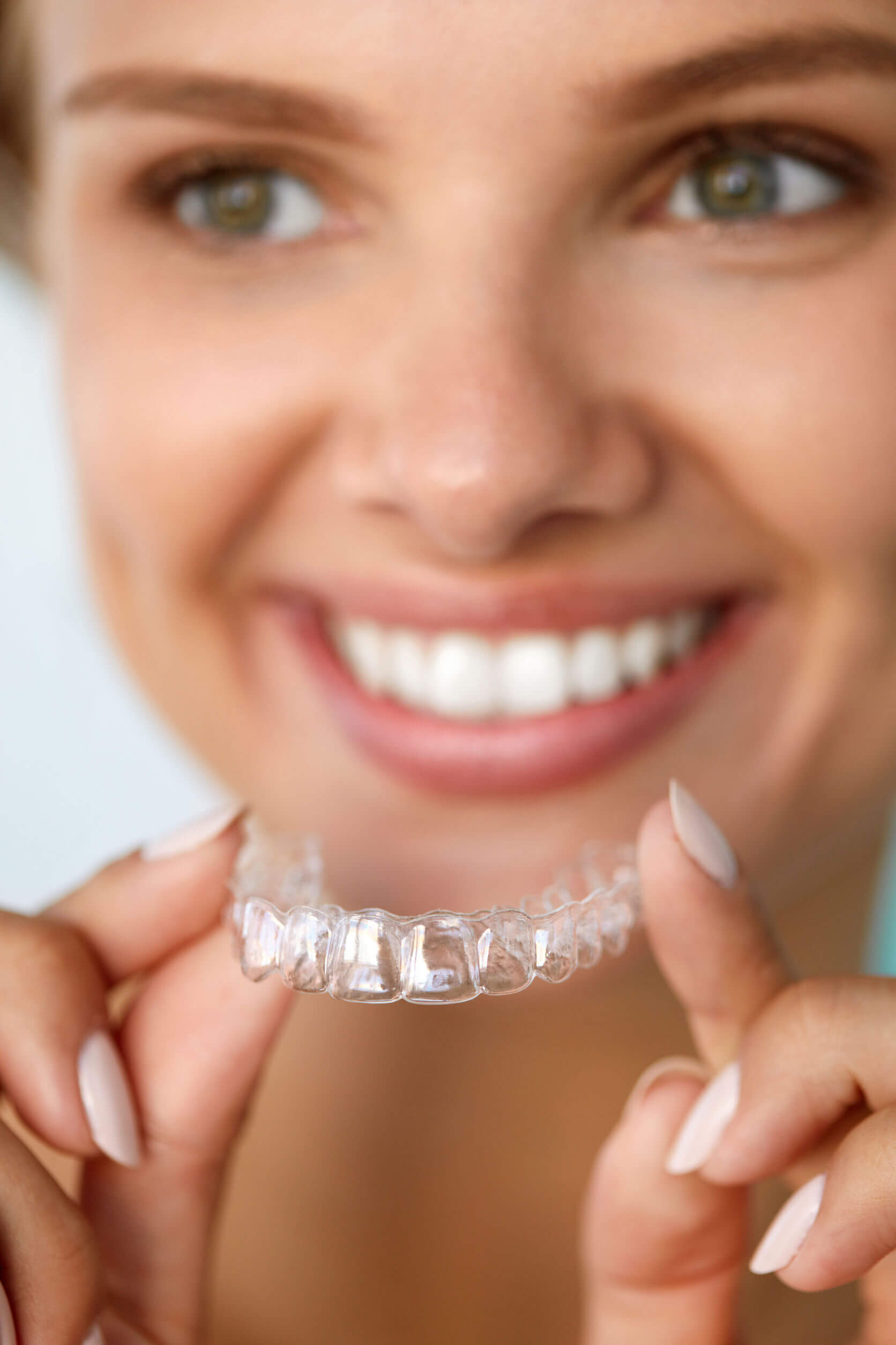 woman putting invisalign on her teeth