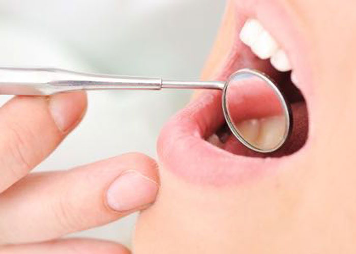 Dental checkup with mirror tool in mouth