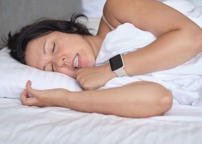 Person sleeping with smartwatch in bed