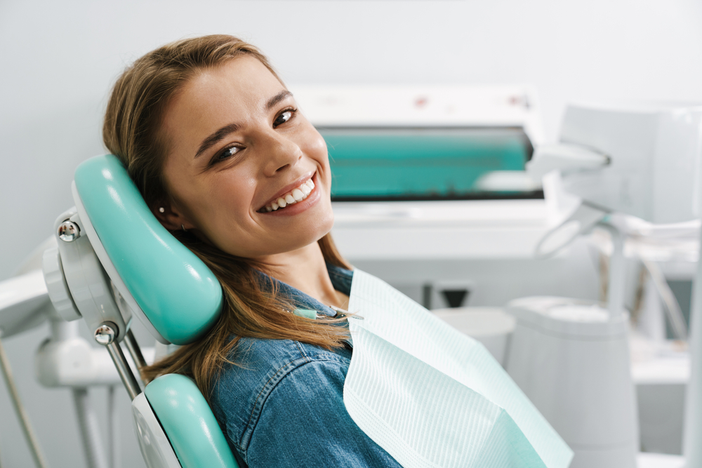 Smiling woman in dental chair at dentist office.